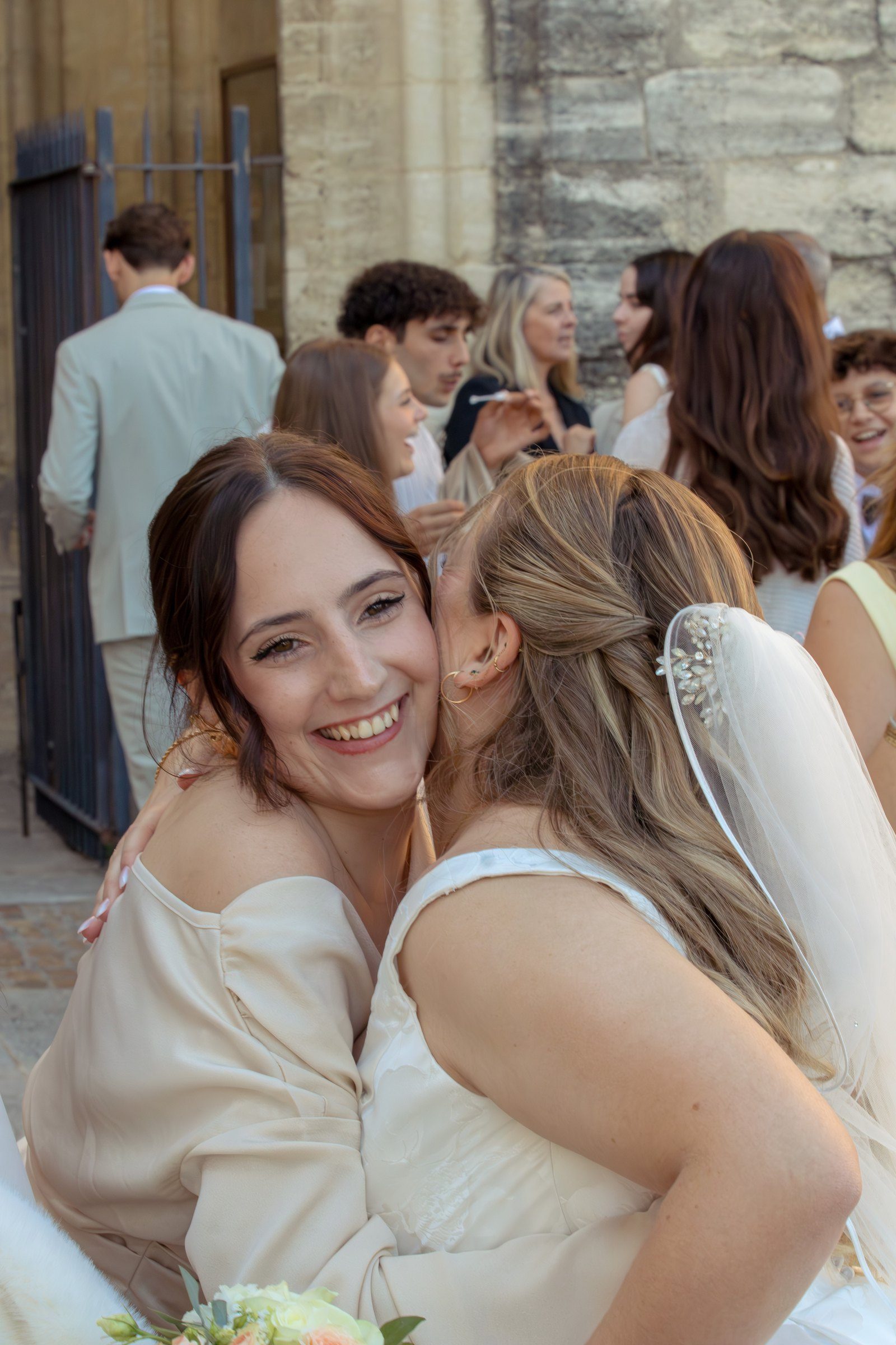 La mariée serre une amie dans ses bras, toutes deux émues