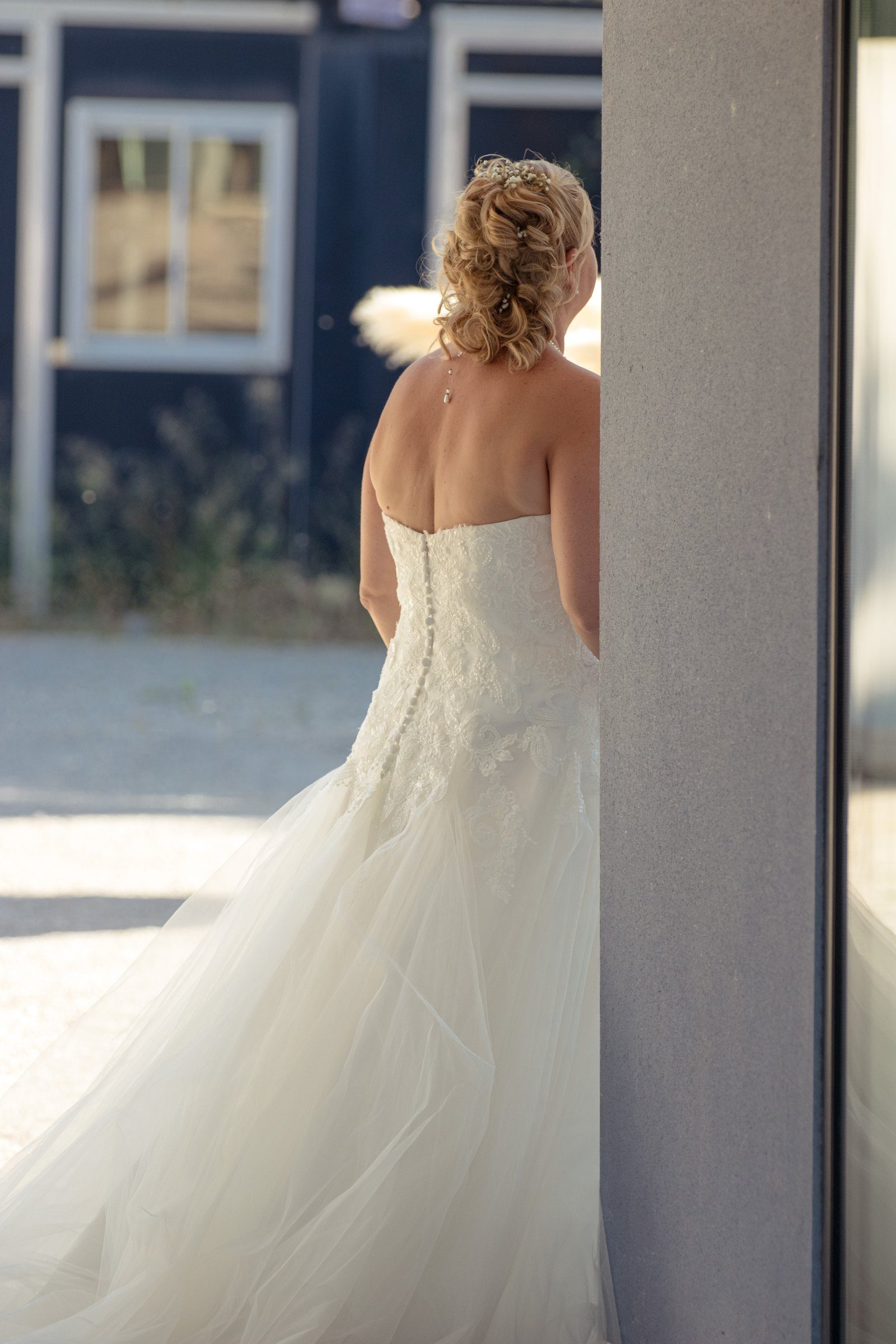 La mariée de dos, appuyée contre un pilier