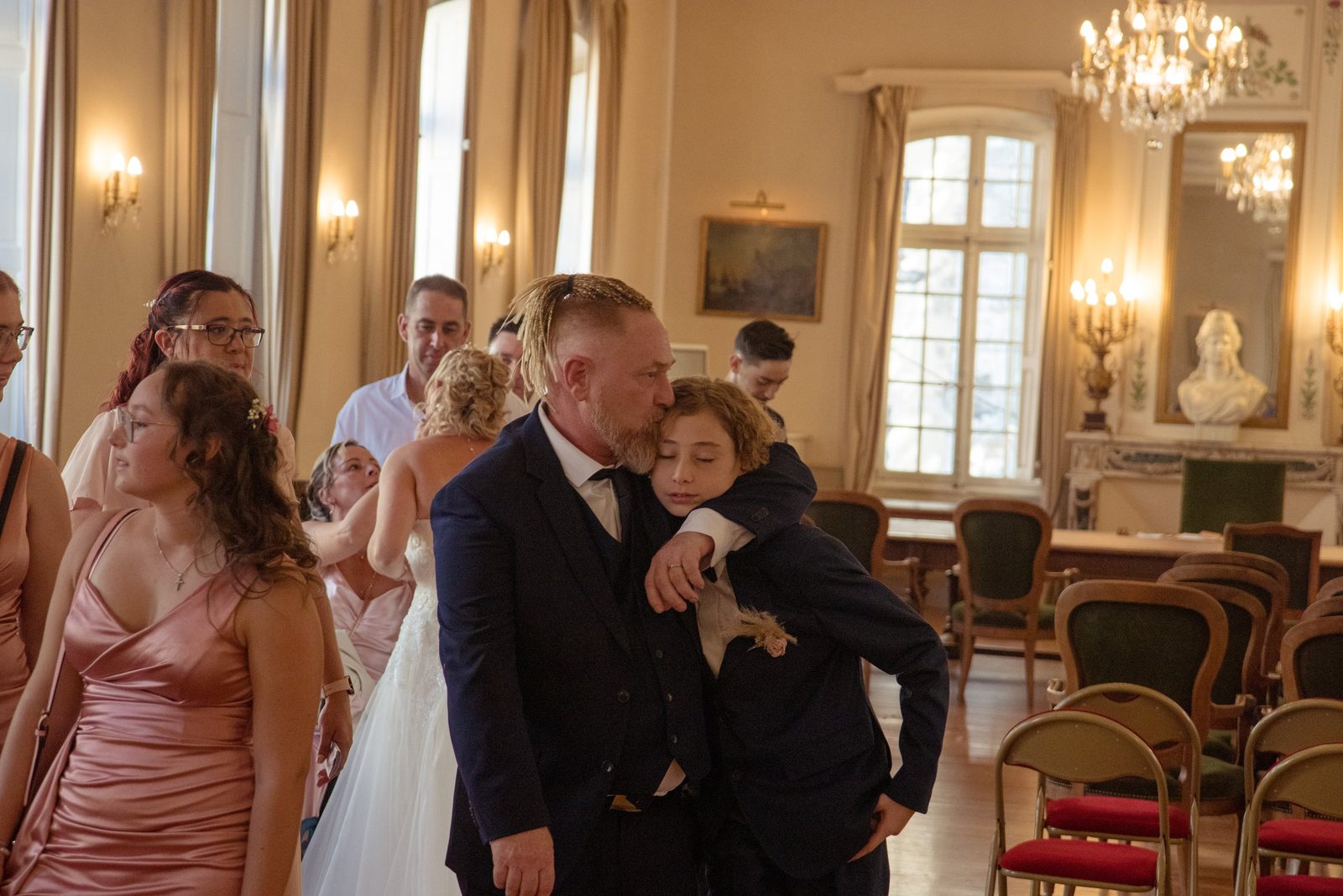 Câlin des mariés avec un enfant dans le salon d'honneur