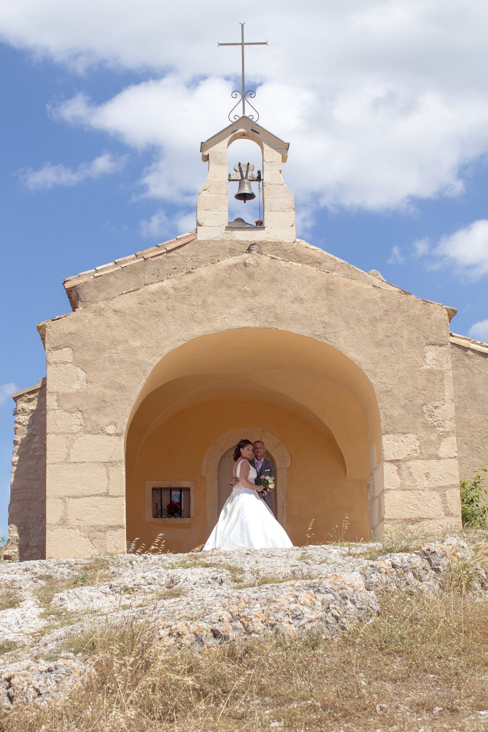 Les mariés sous le porche de la chapelle Saint-Sixte d'Eygalières, dans les Alpilles