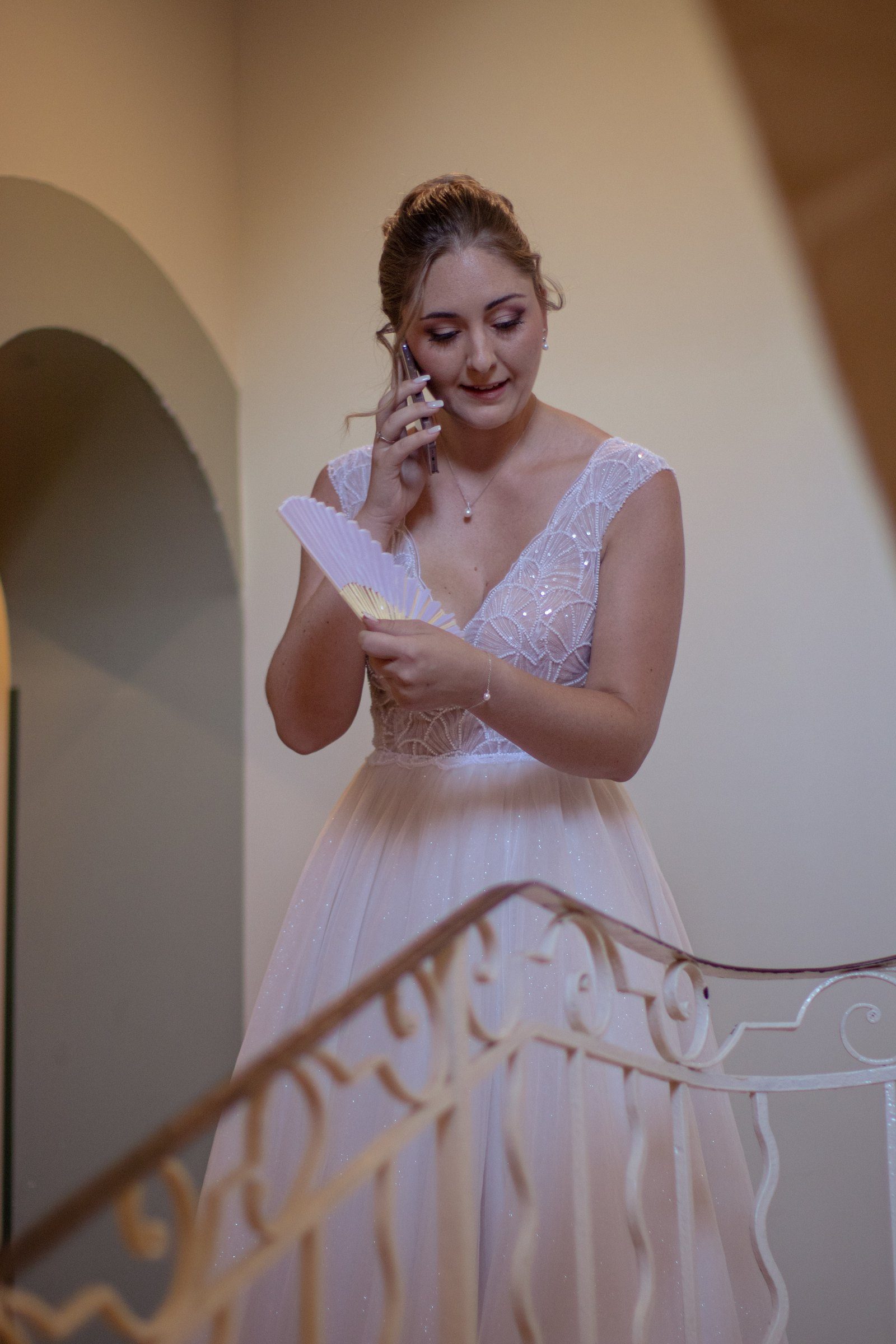 La mariée au téléphone dans l'escalier, prête à partir