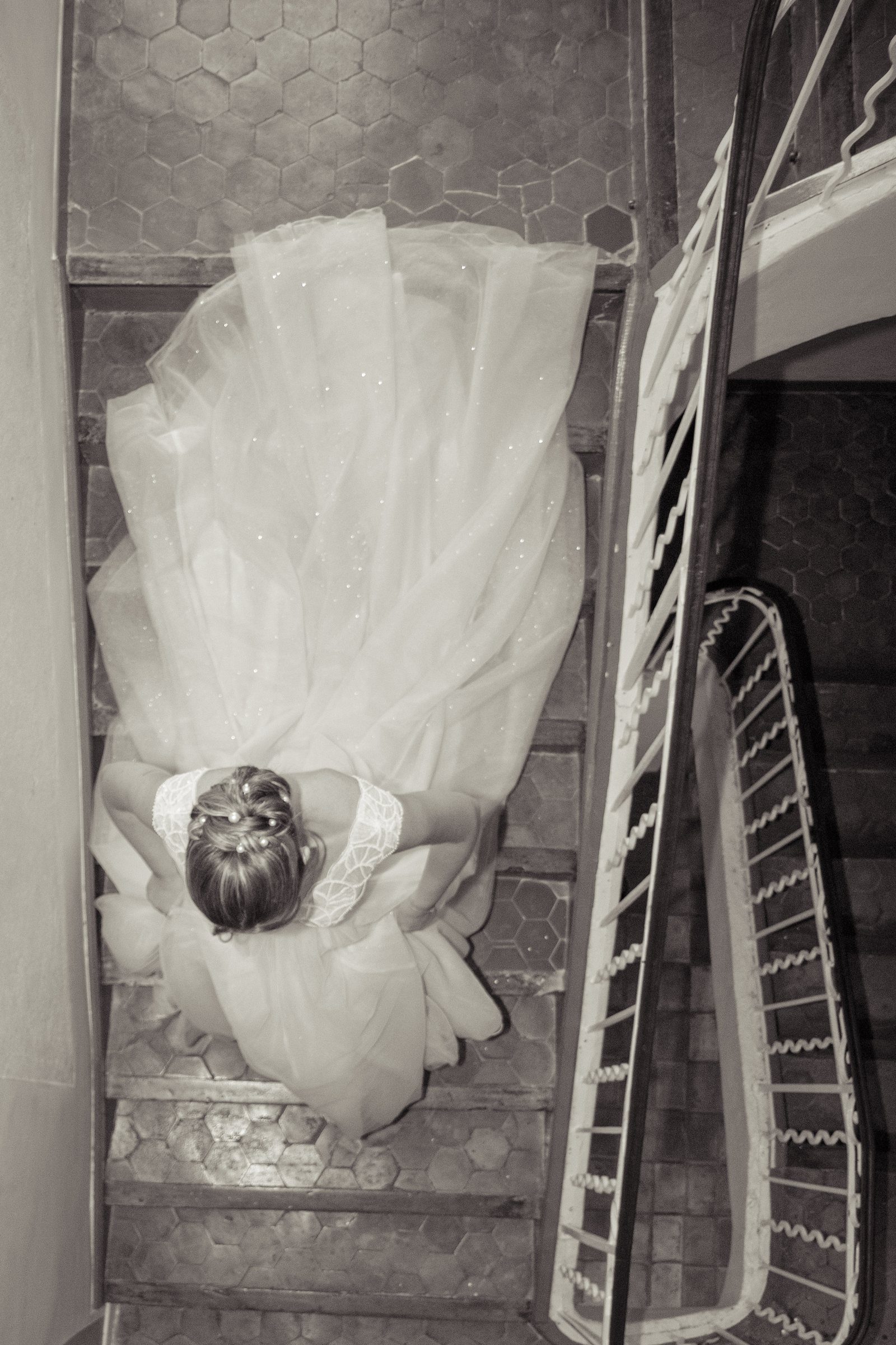La robe de mariée vue d'en haut dans un escalier, en noir et blanc