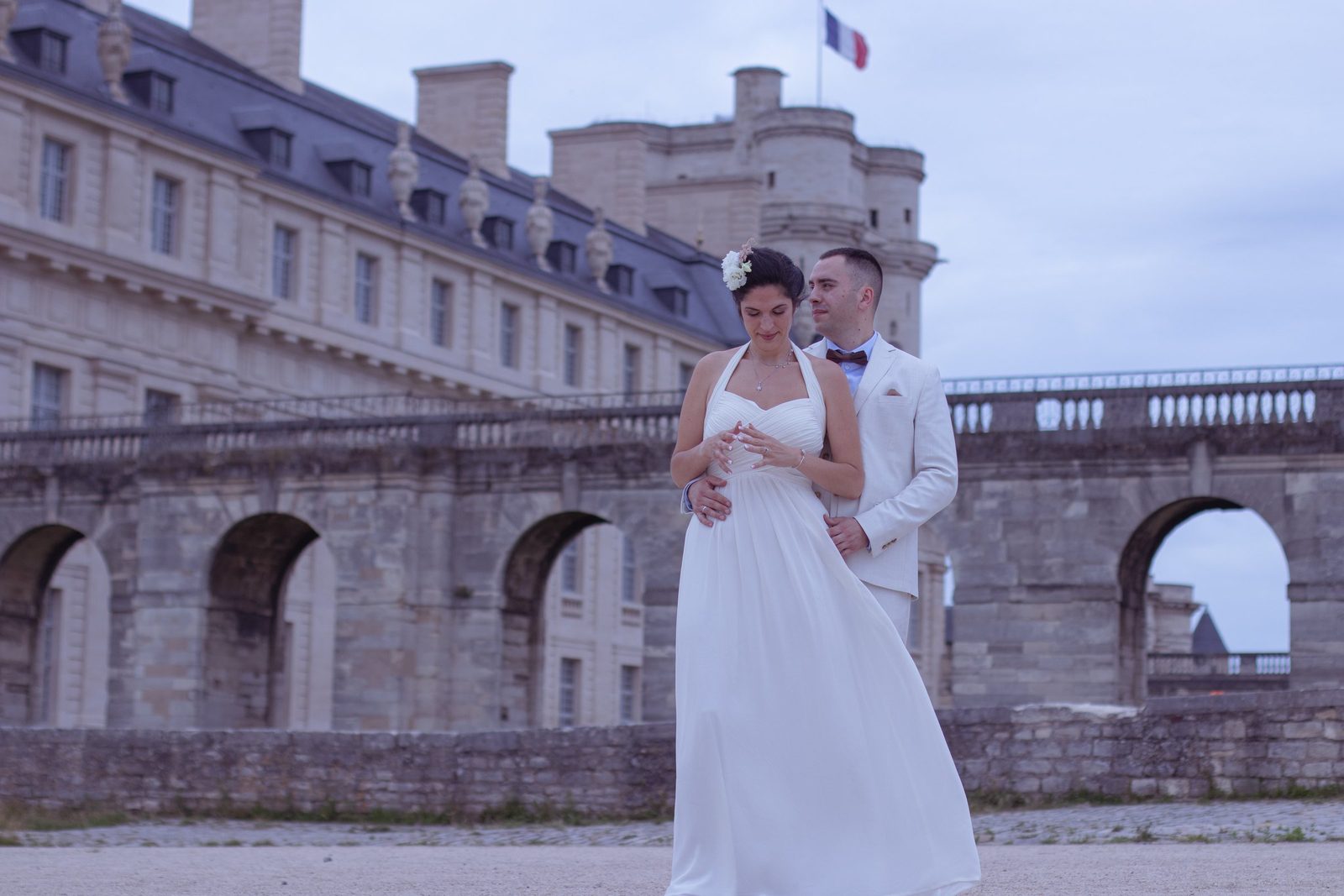 Les mariés devant les arcades d'un château