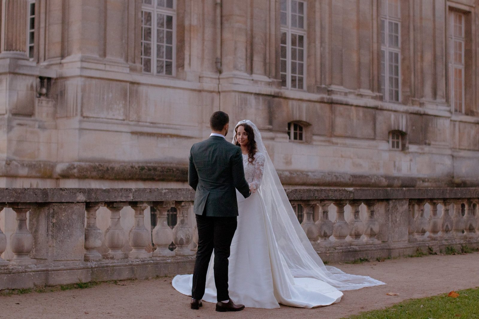 Les mariés face à face devant la façade d'un château