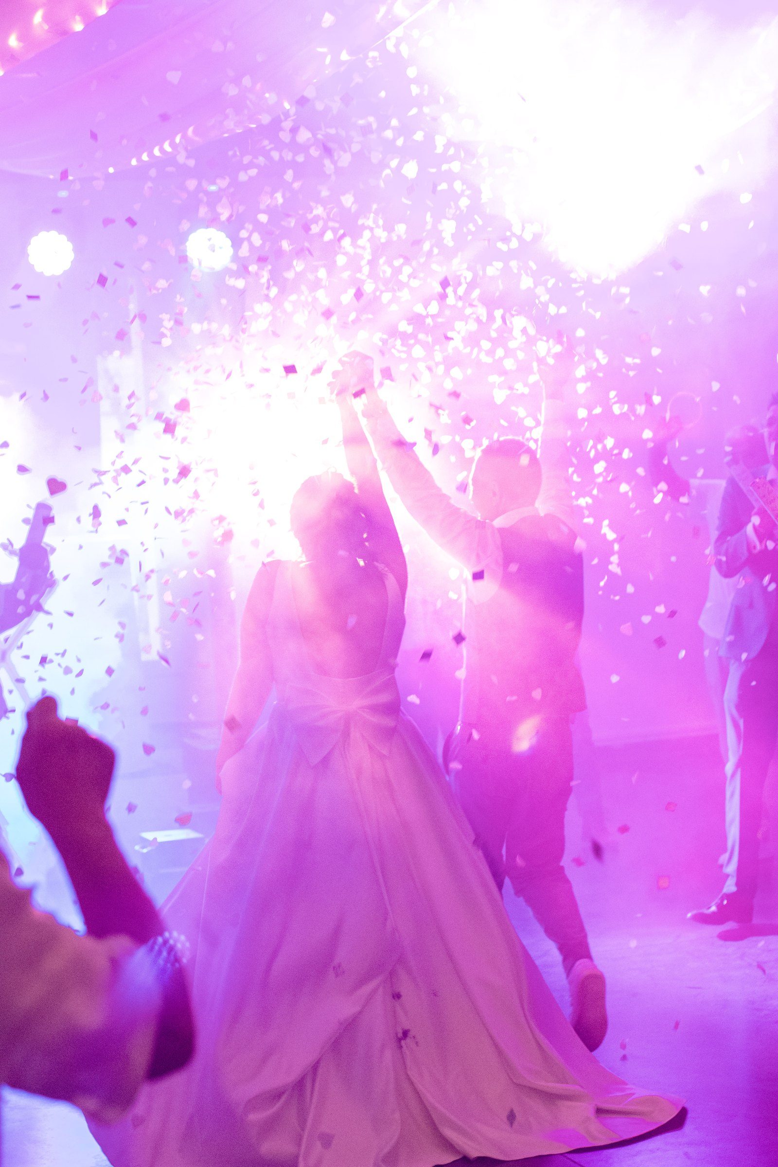 La mariée sous les confettis et la lumière rose